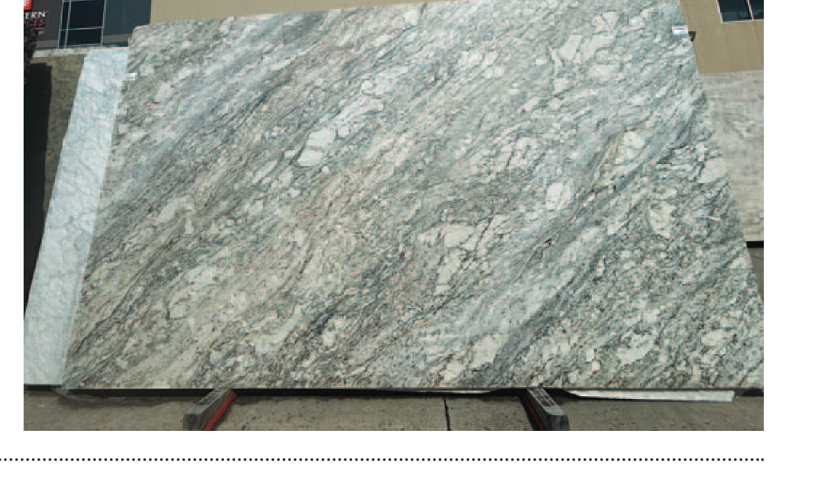 Large slab of stone with a textured pattern displayed outdoors.