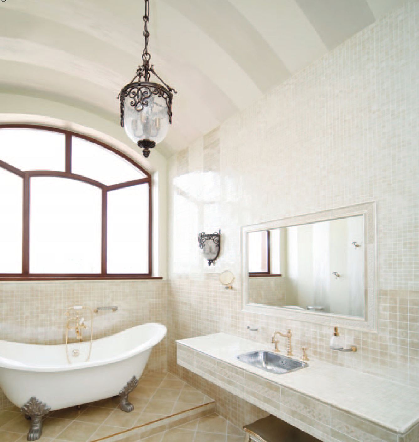 A vintage-style bathroom with a freestanding bathtub, ornate chandelier, and large window.