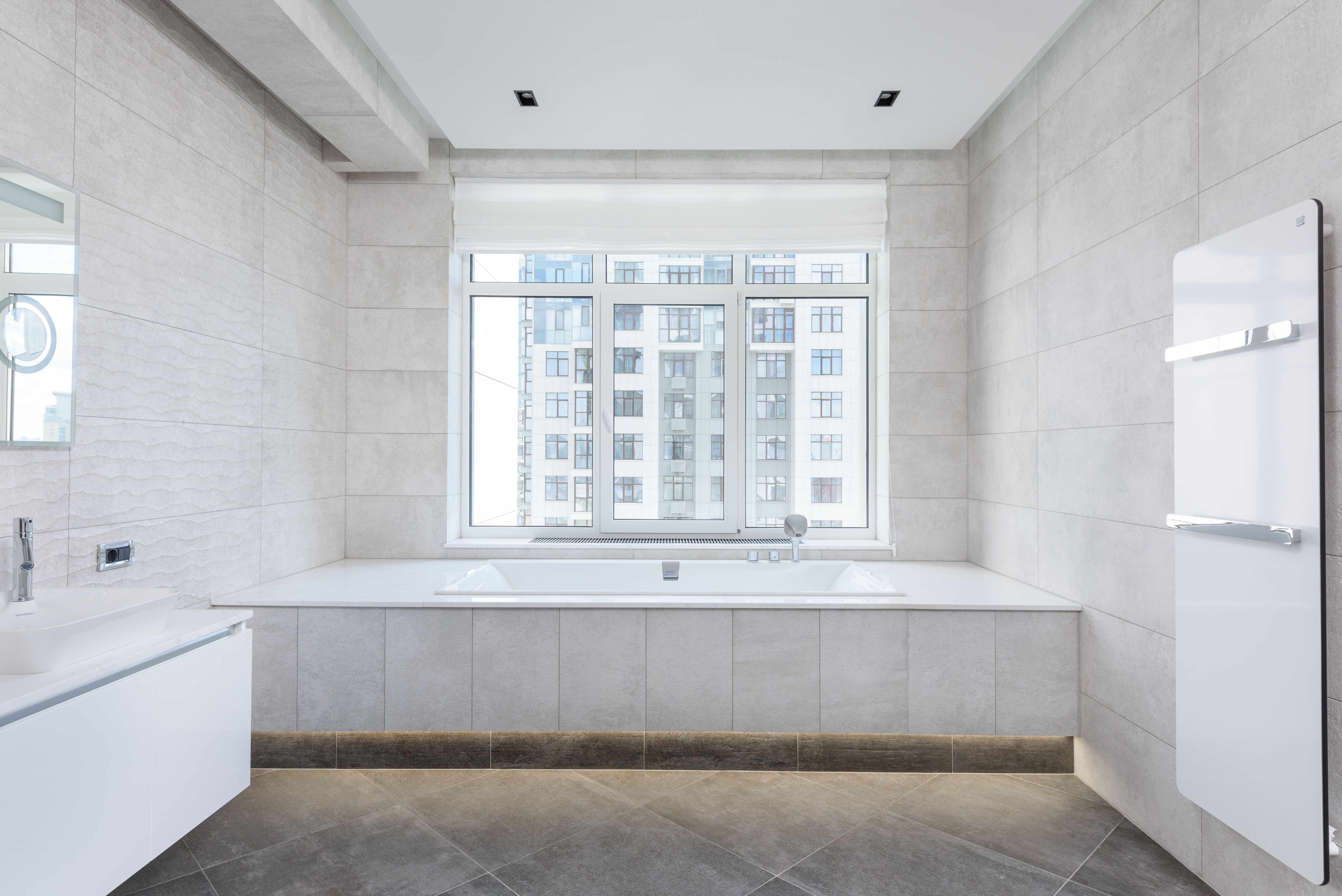 A luxurious bathroom with a focus on high-end spa features. Display a freestanding tub, walk-in shower, and heated floors, all in a cohesive, stylish 