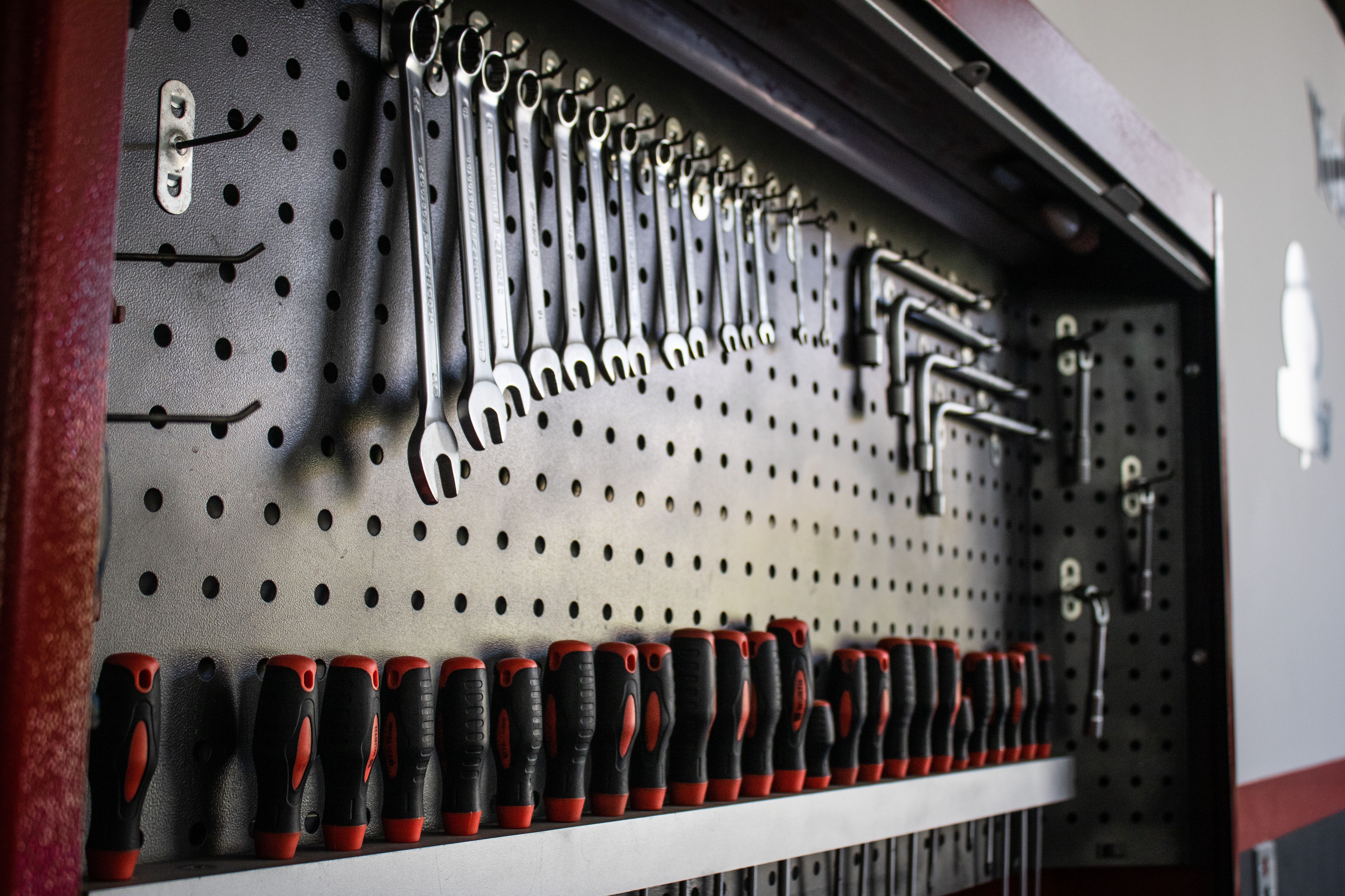 A photorealistic image of vertical and overhead garage storage solutions, featuring ceiling-mounted racks, wall-mounted shelves, and loft storage, max