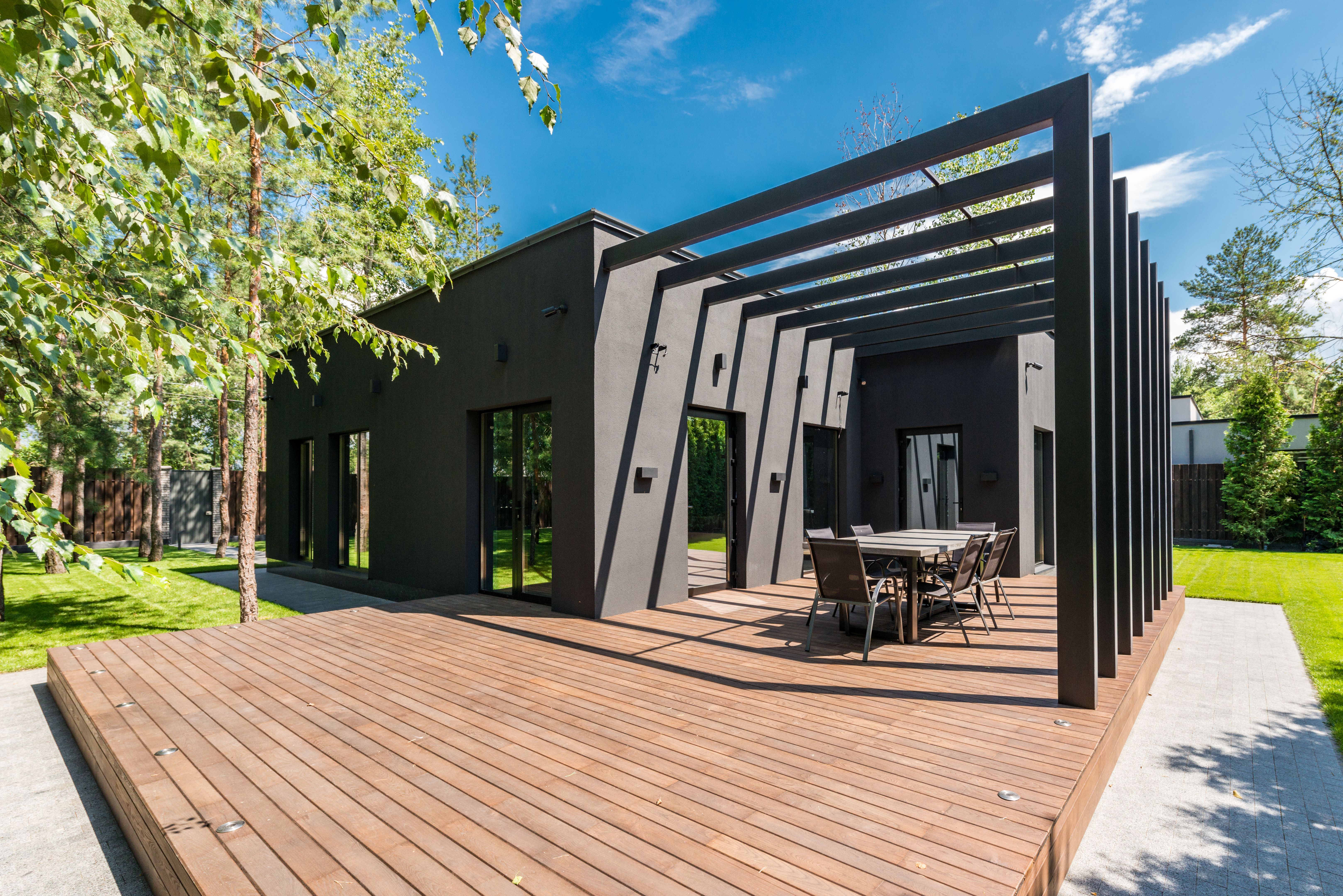 A modern pergola featuring integrated smart technology, such as adjustable lighting and climate control systems. The pergola is constructed with sleek