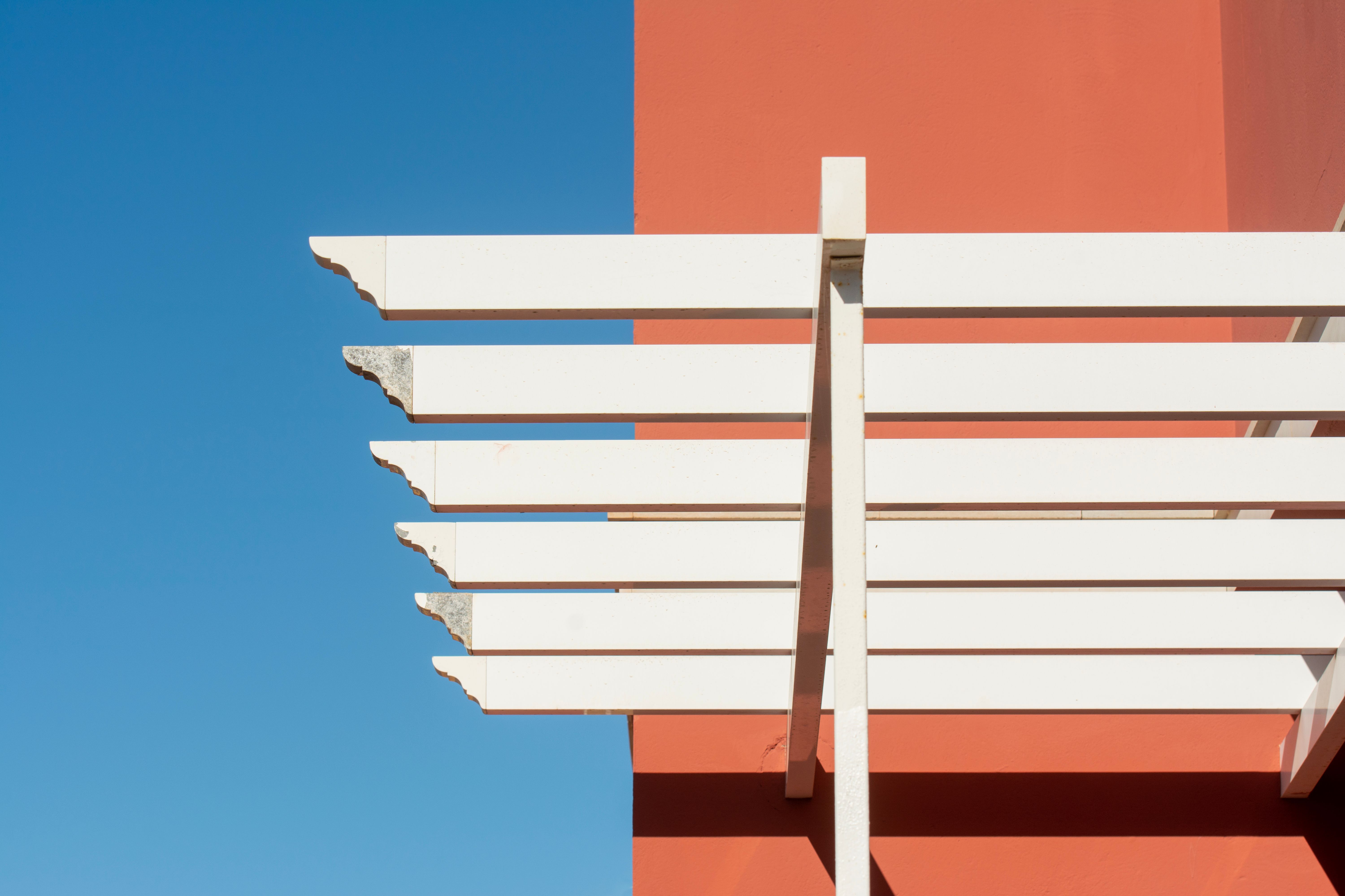 A minimalist pergola design with clean lines and neutral colors, blending seamlessly with its natural surroundings. The structure incorporates biophil