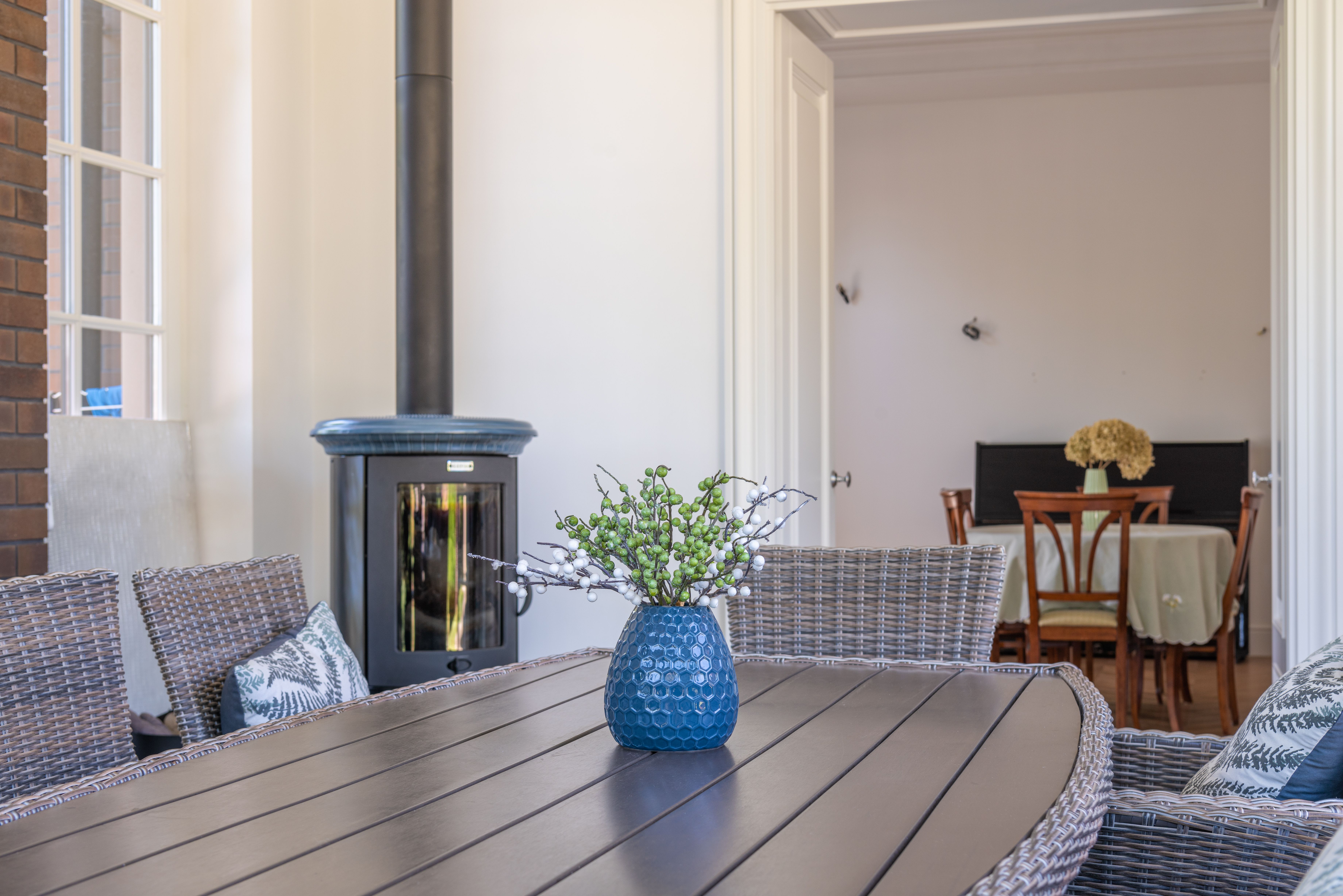 A modern outdoor living space with a functional outdoor kitchen, entertainment area, and cozy seating around a stylish fire pit. The space is designed