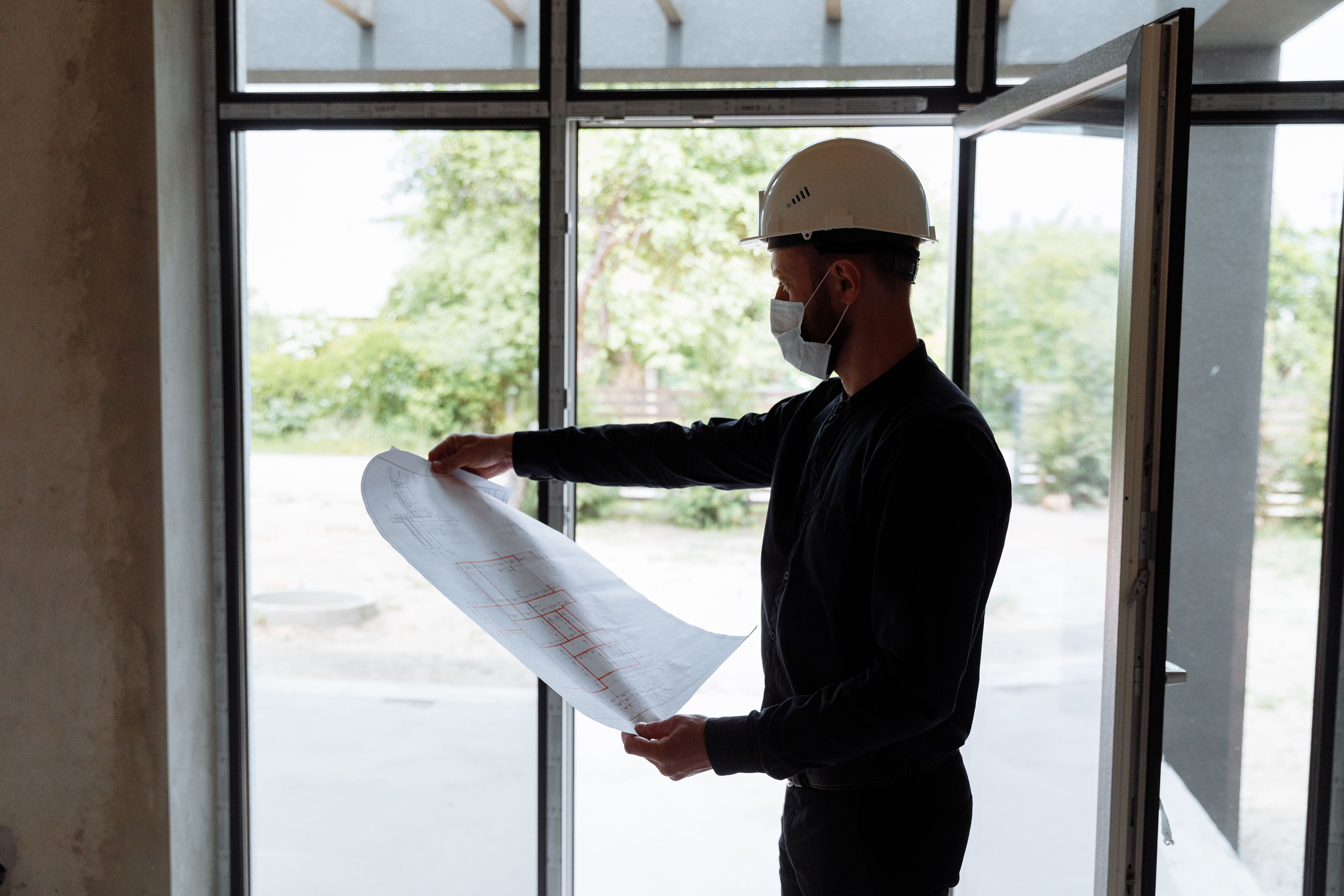 An image illustrating a contractor reviewing local zoning laws and building plans with a focus on compliance and regulation, showcasing architectural 