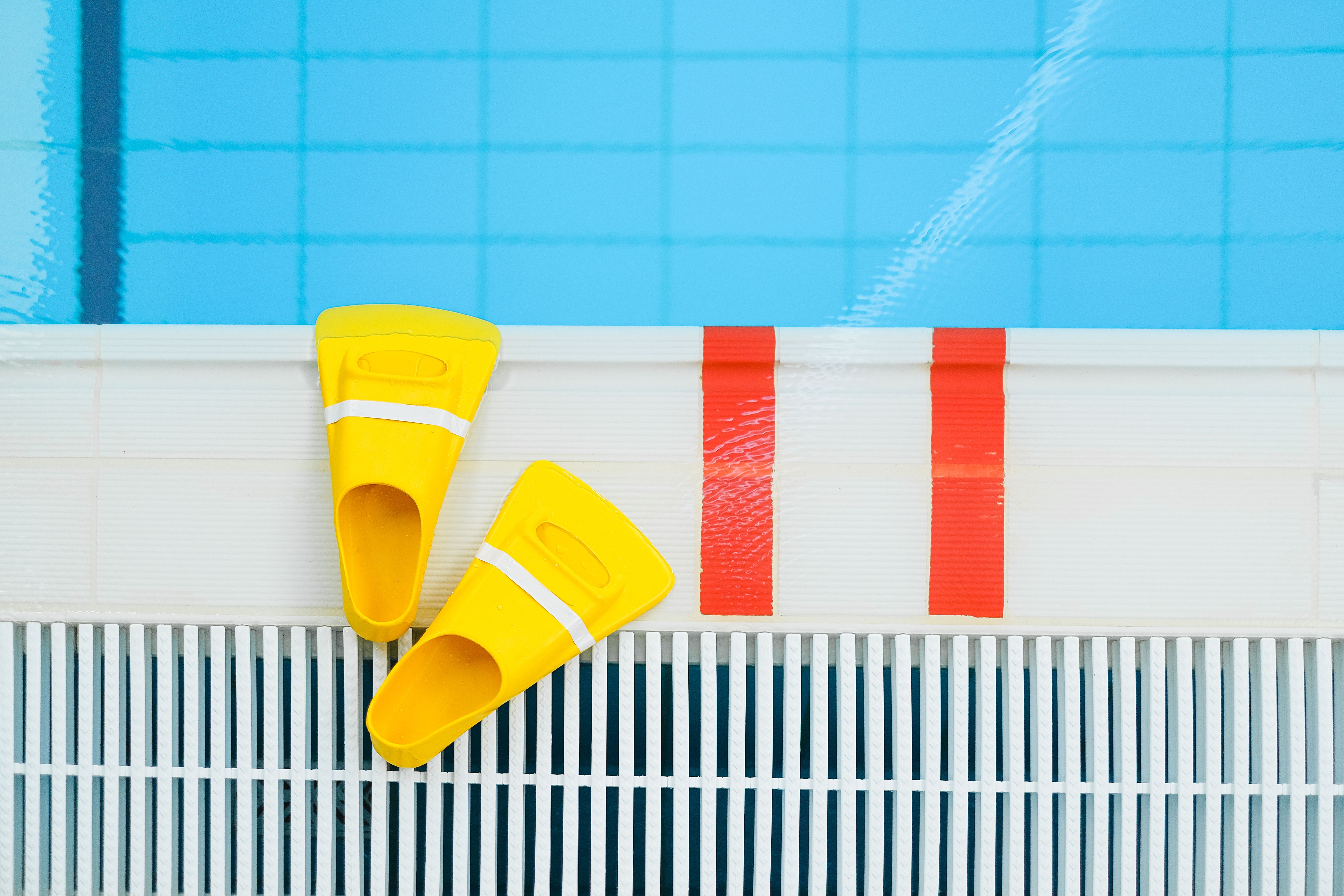 A poolside view with safety equipment, including life rings and a safety barrier, with a clear emphasis on safety and compliance, under a sunny, clear
