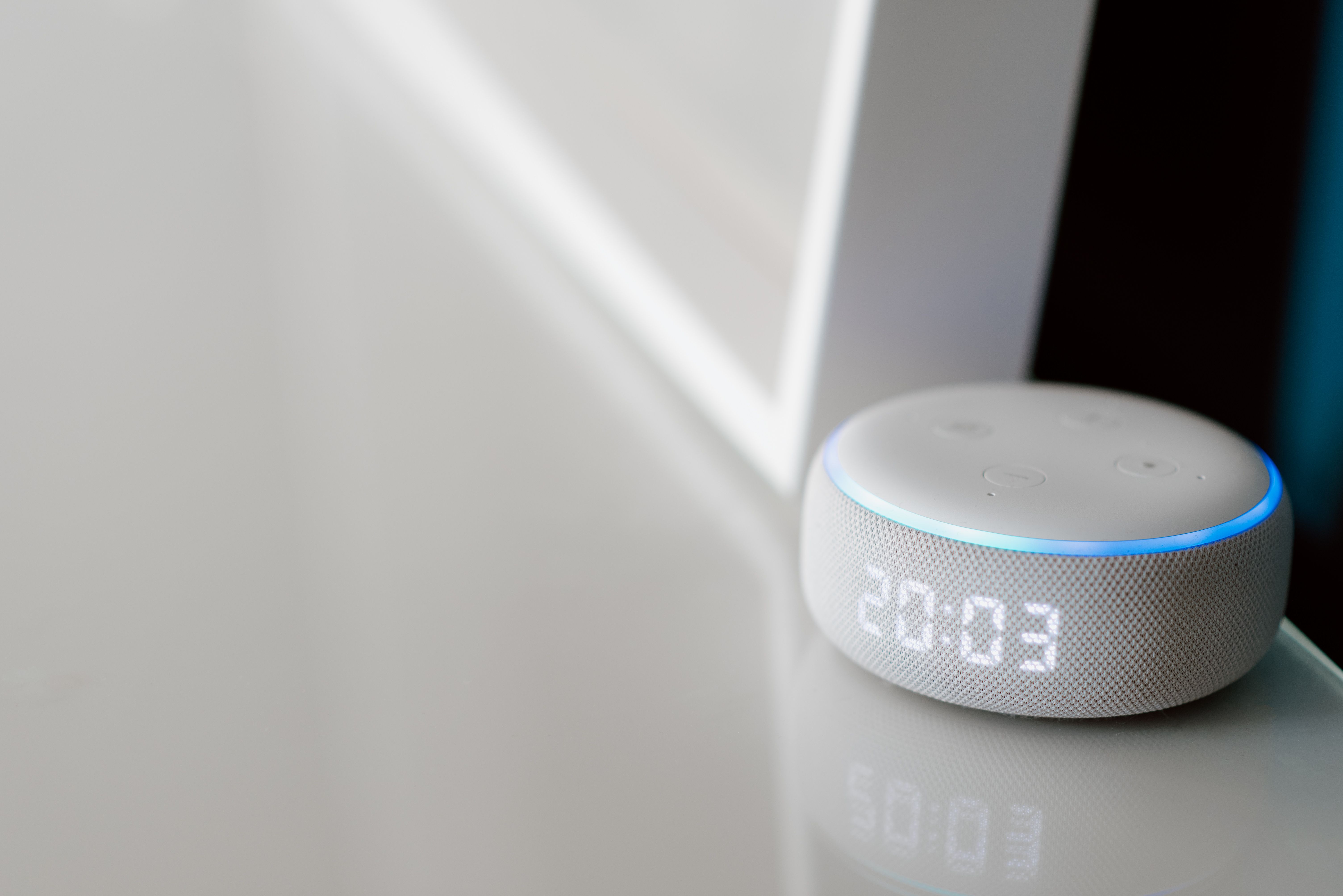 An array of IoT devices such as smart cameras, door sensors, and a central hub displayed on a table, illustrating the rise of smart home technology. T