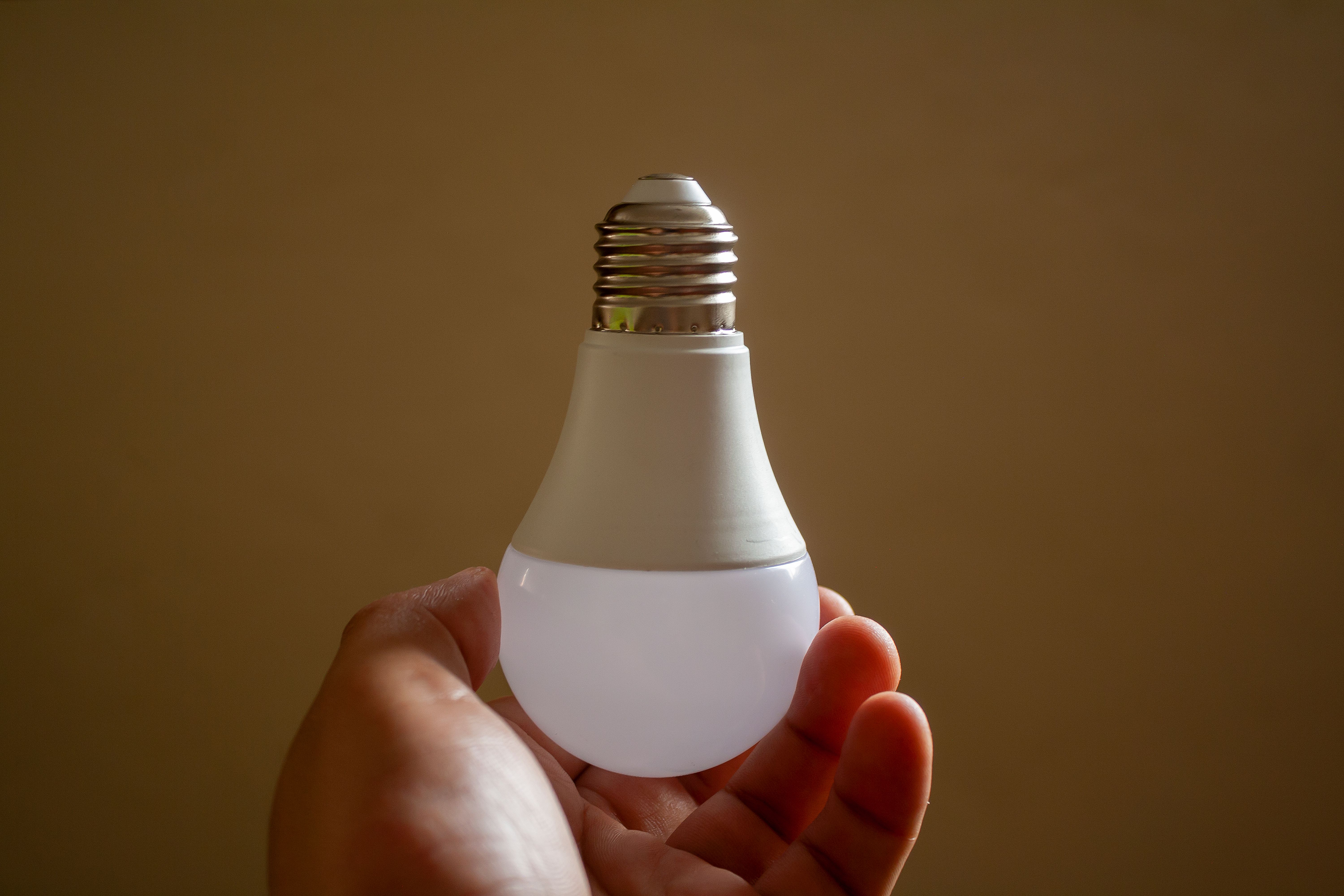 A close-up view of a smart light bulb with visible IoT chip, demonstrating the technology that enables remote control and automation. The bulb should 