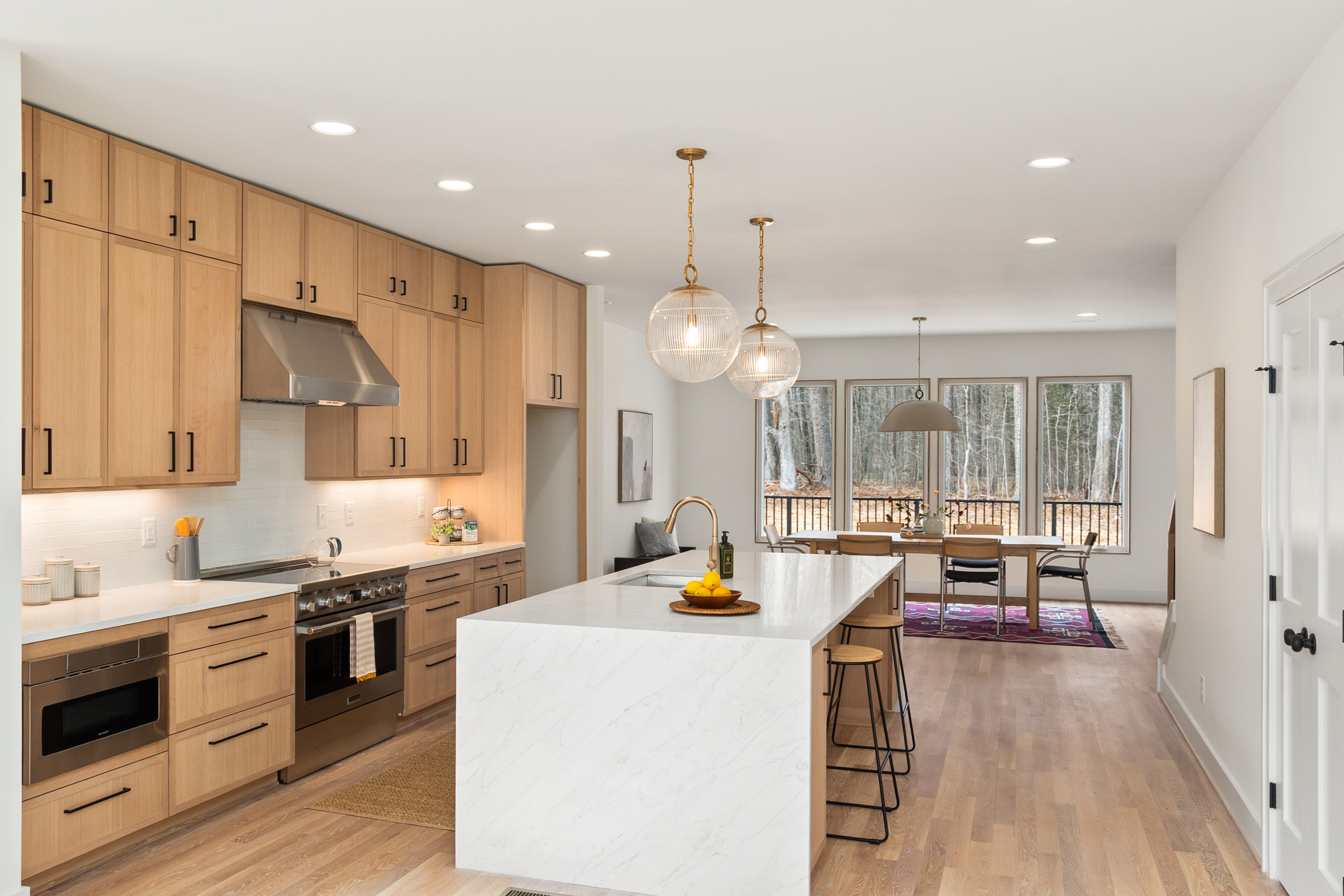 A kitchen with two-tone cabinets, combining natural wood finishes with painted surfaces. The image should show the contrast and depth added to the kit