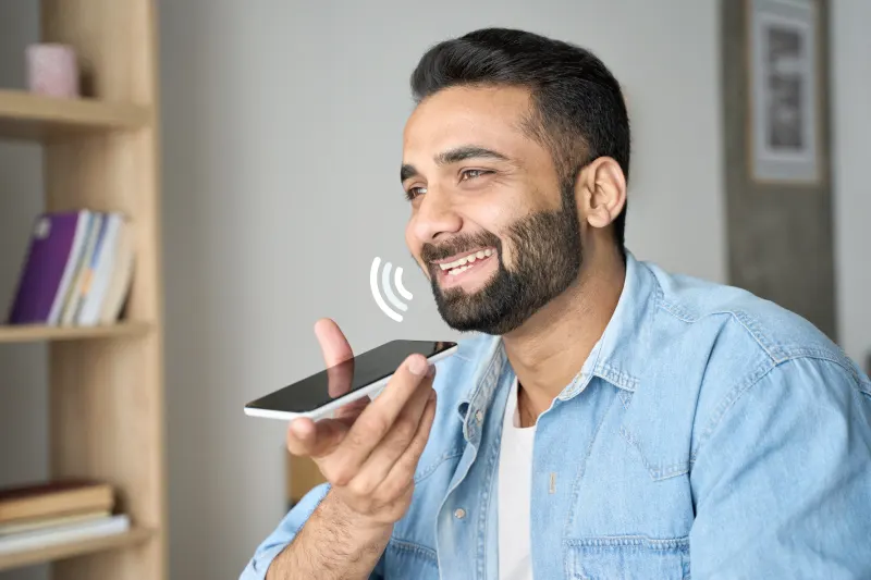 A person using voice search on a smartphone, with conversational keywords highlighted in the search bar