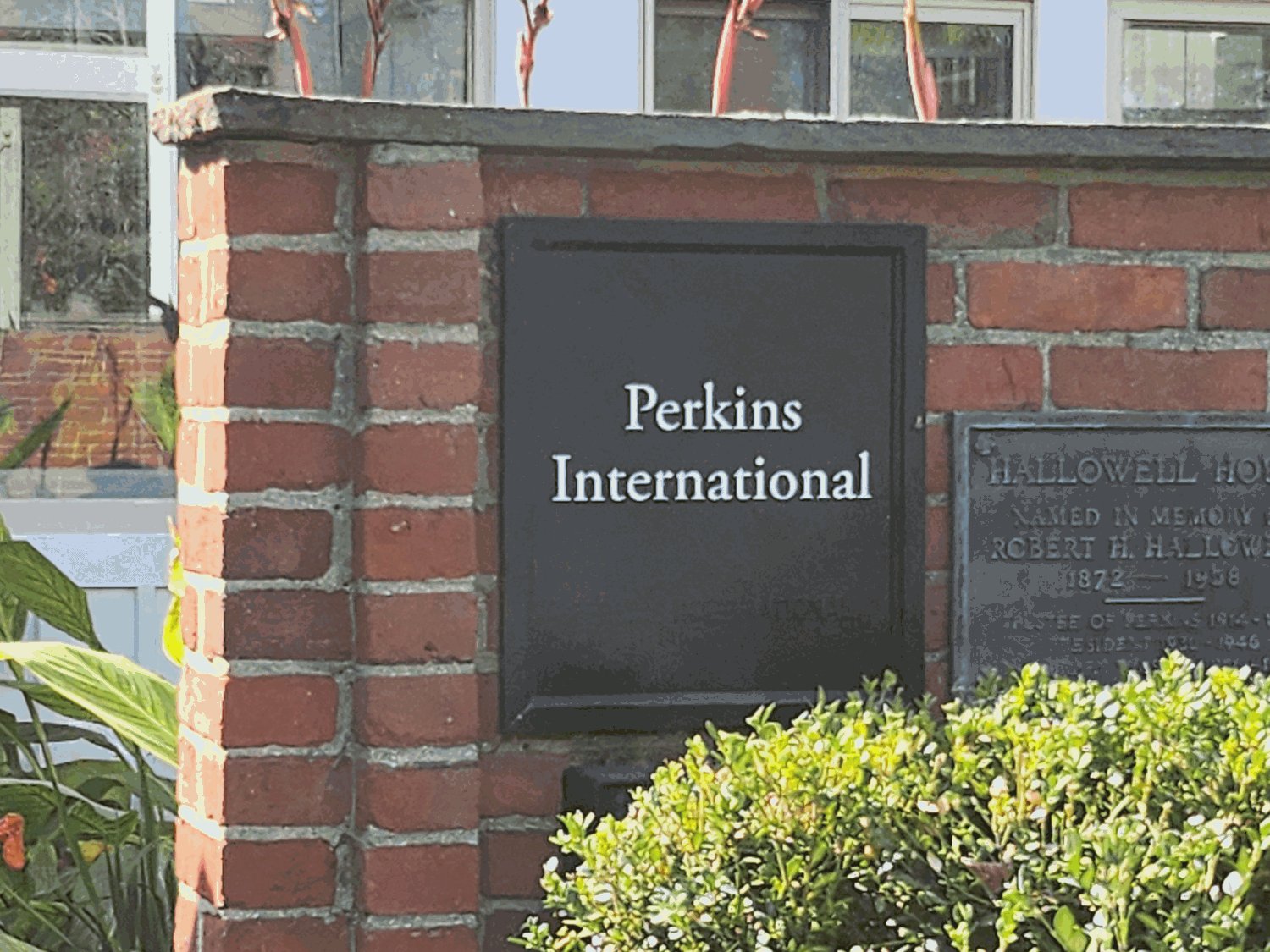 붉은 벽돌 기둥에 「Perkins International」이라고 적힌 검은 현판