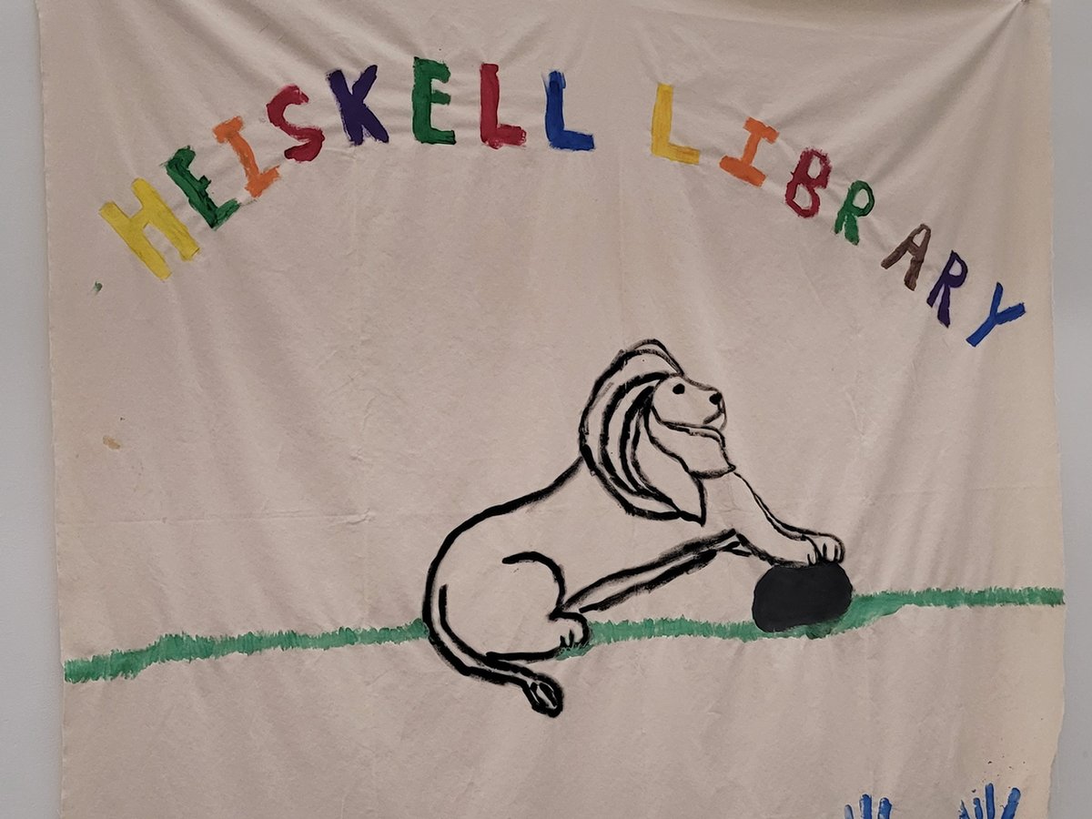 「HEISKELL LIBRARY」 글자와 사자, 파란 손도장이 그려진 천 현수막