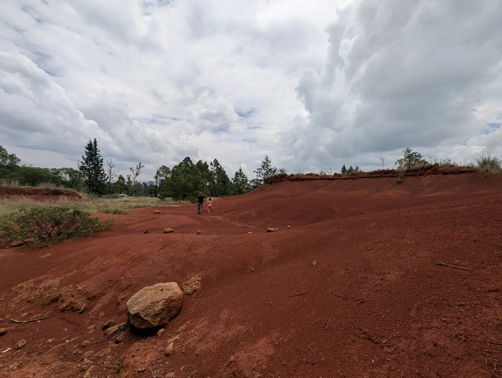 Sendero entre tierra rojiza y cielo nublado en las Dunas Rojas de Amealco, destino natural de Querétaro.