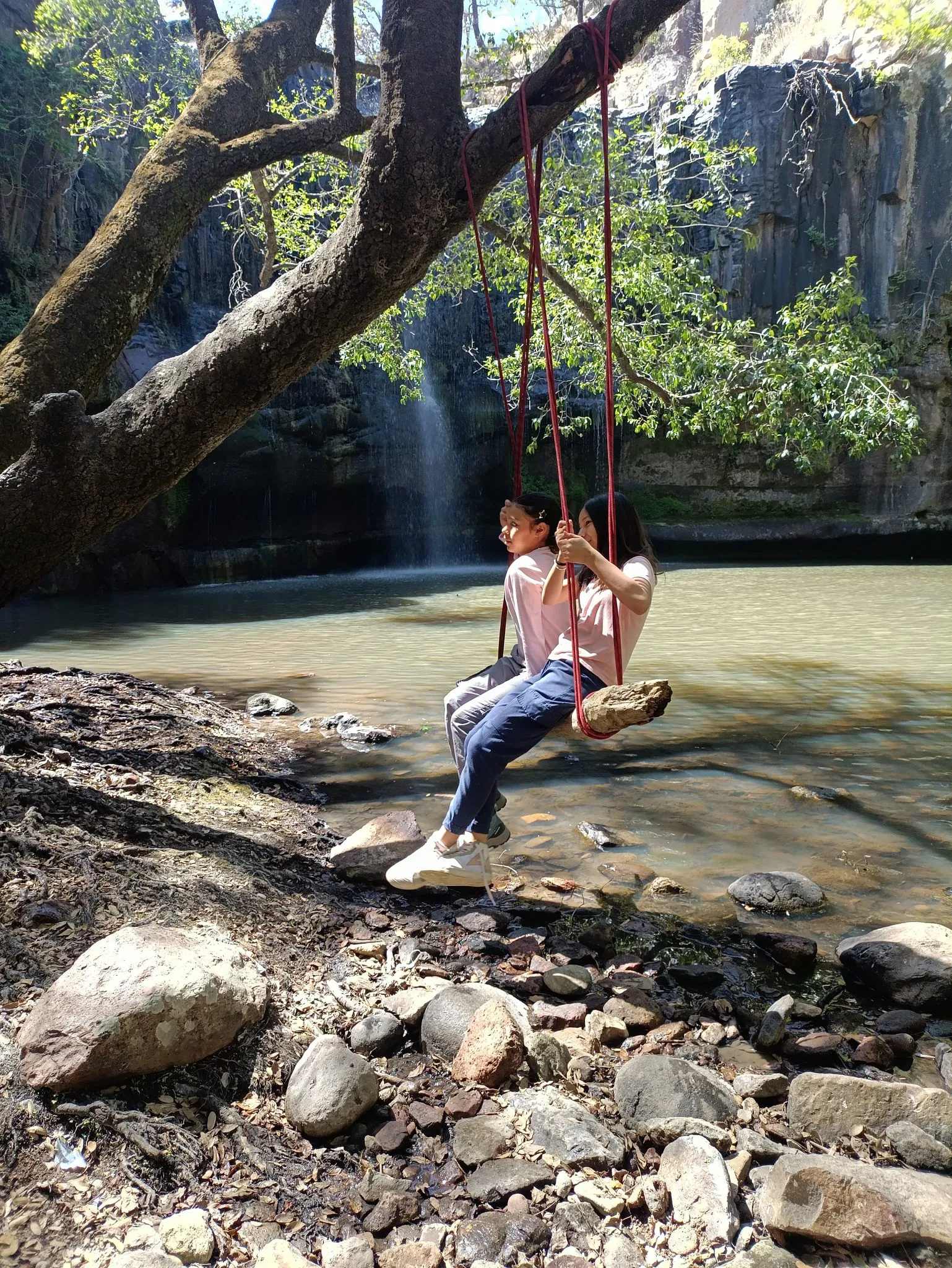 Visitantes disfrutando de un columpio junto a la poza y cascada de Tixhiñú, Aculco.