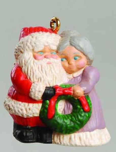 Mr. & Mrs. Kringle Holding Wreath