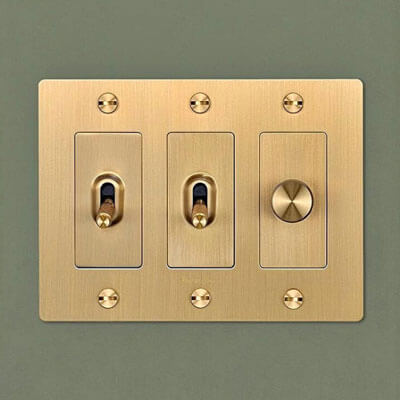 brass Buster + Punch light switch with textured switches