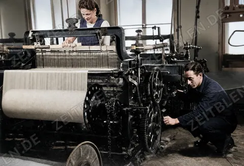 Arbeiterin und Mechaniker an einem Webstuhl der Münchner Rosshaarfabrik