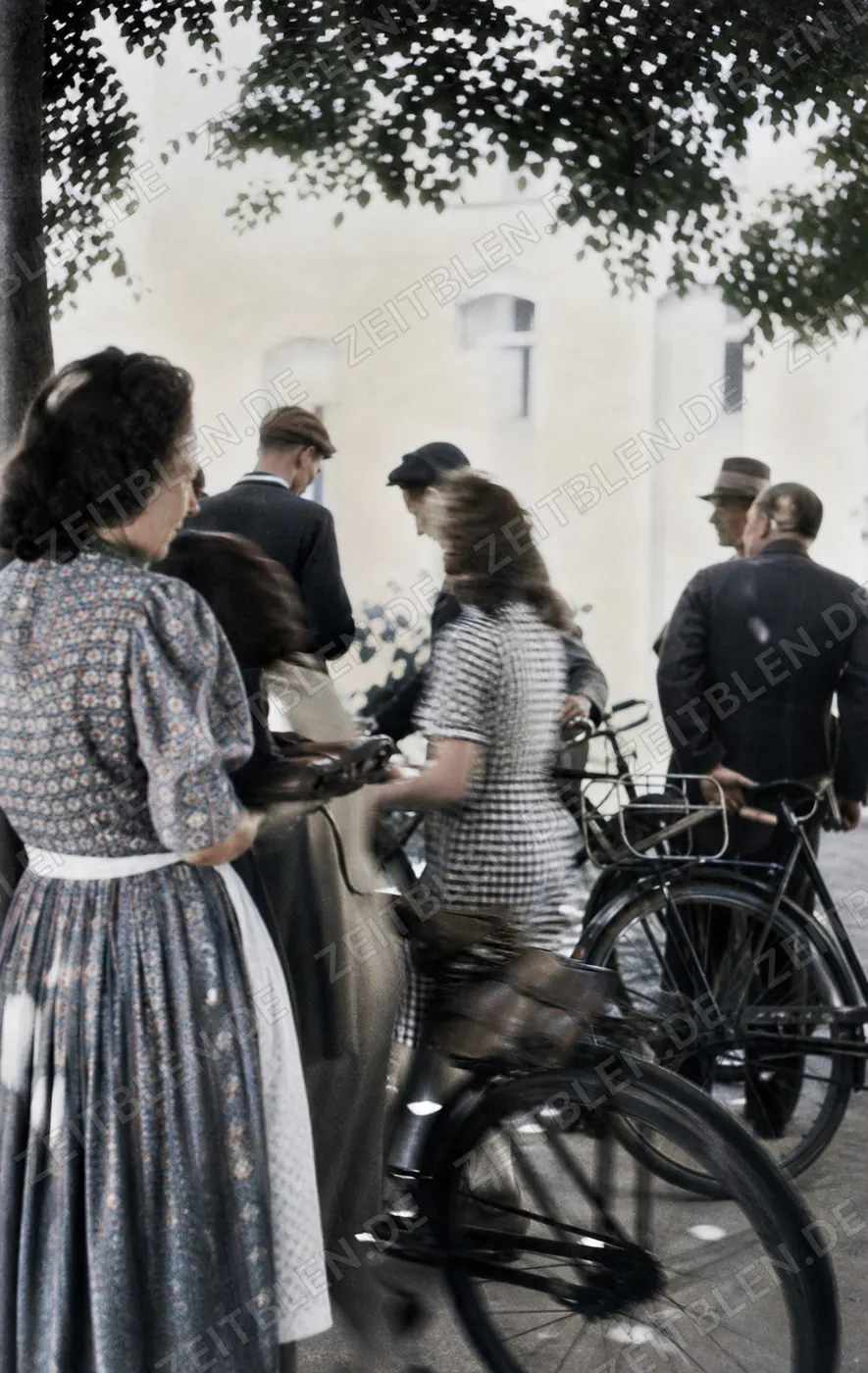 Personengruppe mit Fahrrad im Schwarzmarktumfeld