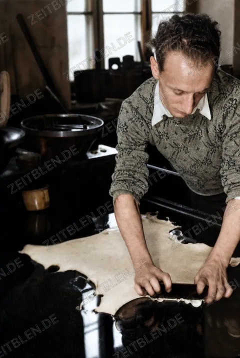 Mitarbeiterin prüft Leder in der Handschuhfabrik Röckl