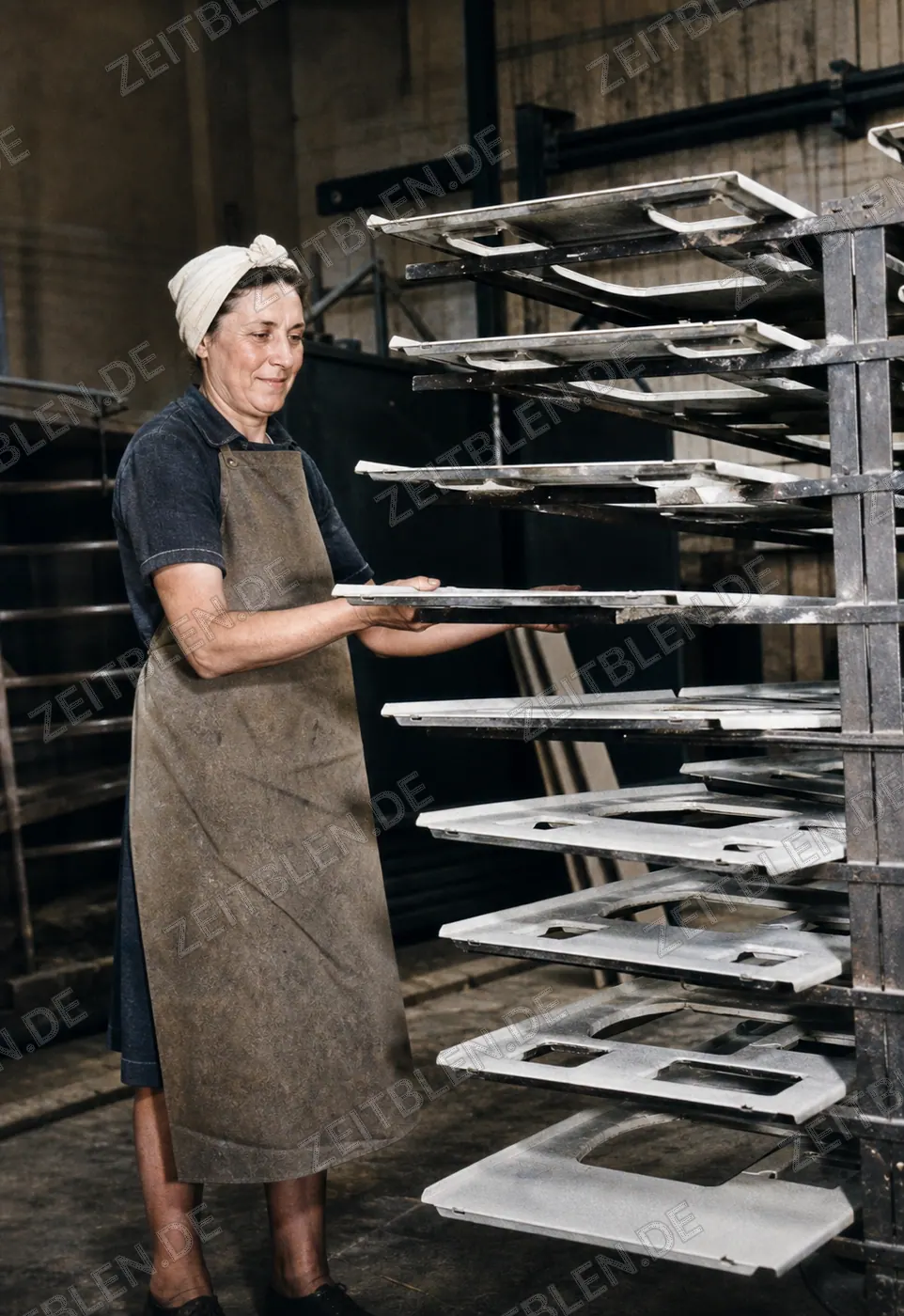 Arbeiterin an aufgehängten Herdbauteilen bei Wamsler