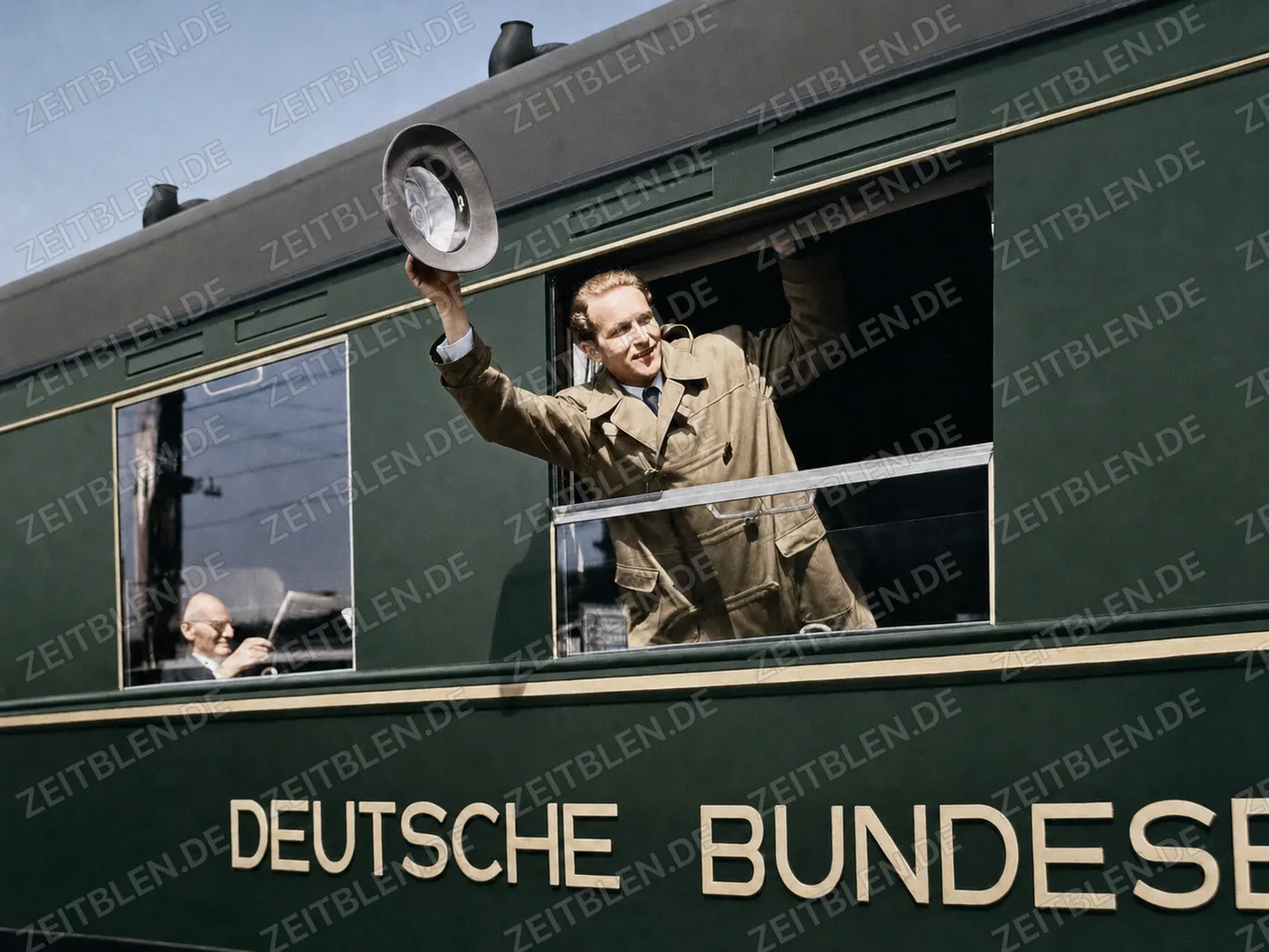 Bahnreisender winkt aus dem abfahrenden Zug
