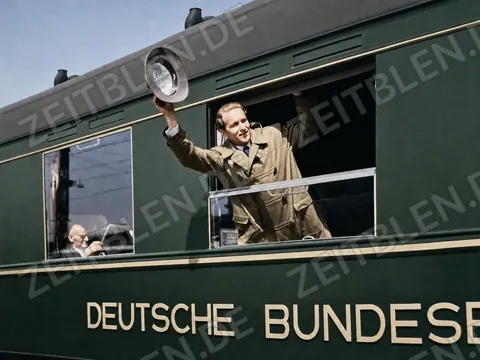 Bahnreisender winkt aus dem abfahrenden Zug