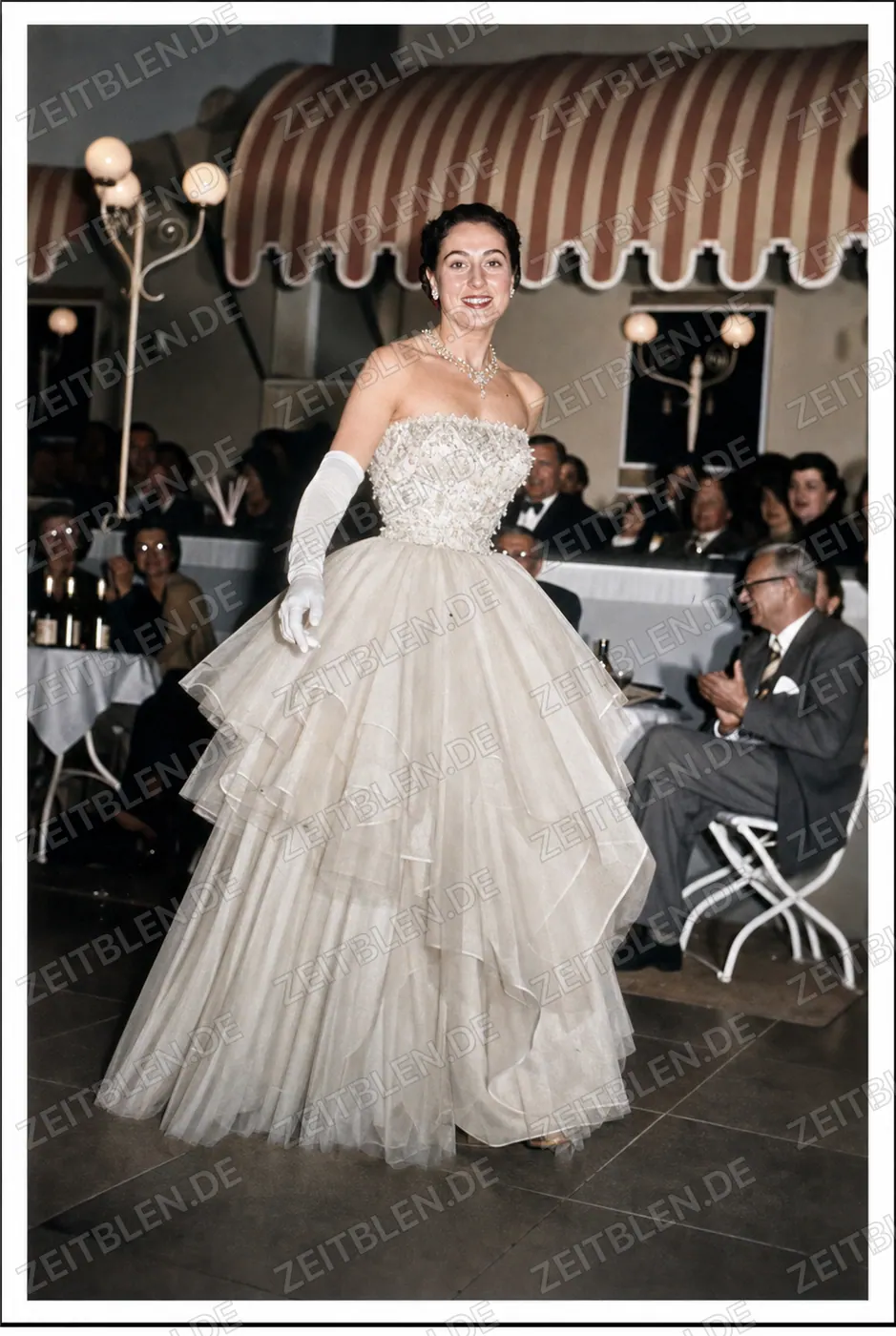Mannequin im weißen Tüll-Abendkleid bei der Modeschau „Elegante Welt“