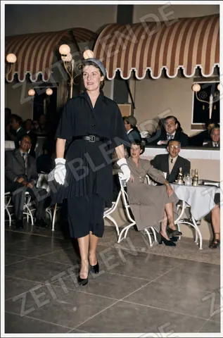 Mannequin im dunklen Kostümkleid bei der Modeschau „Elegante Welt“