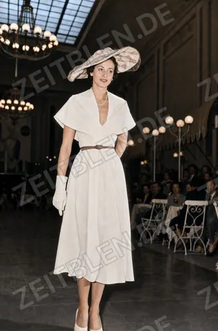 Mannequin im hellen Kleid mit großem Hut bei „Kultur und Mode“