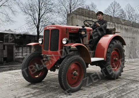 Schlüter-Schlepper mit Fahrer vor Hofgebäuden