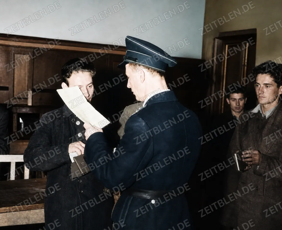 Münchner Polizist prüft Papiere bei einer Personenkontrolle, 25. Oktober 1946