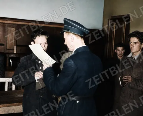 Münchner Polizist prüft Papiere bei einer Personenkontrolle, 25. Oktober 1946