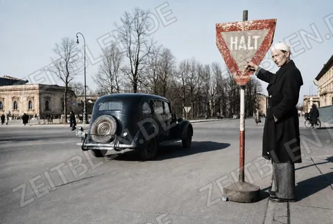 Mann am Halt-Schild im Münchner Straßenverkehr