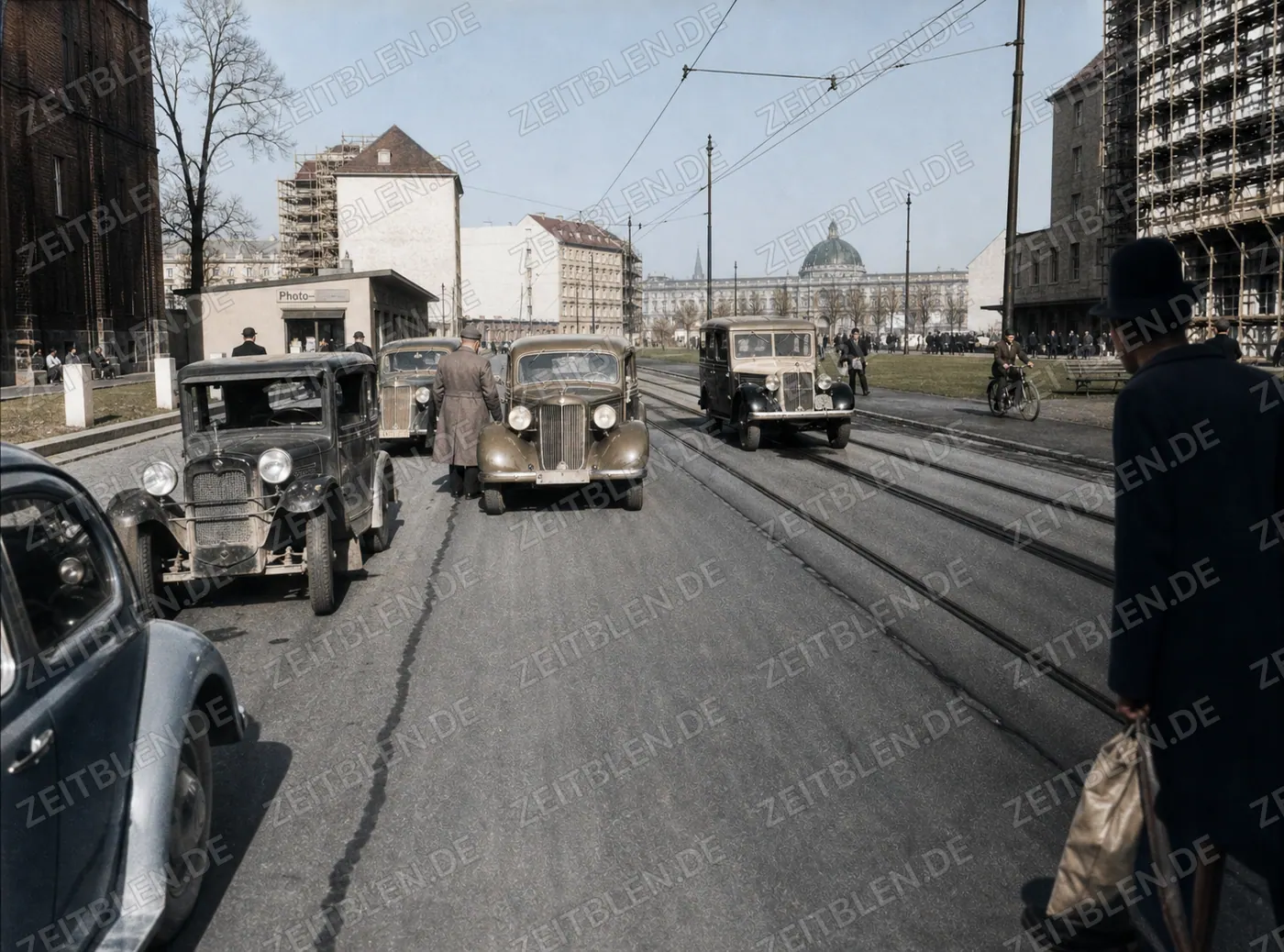 Autoverkehr auf breiter Münchner Straße mit Gleisen