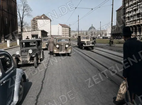Autoverkehr auf breiter Münchner Straße mit Gleisen