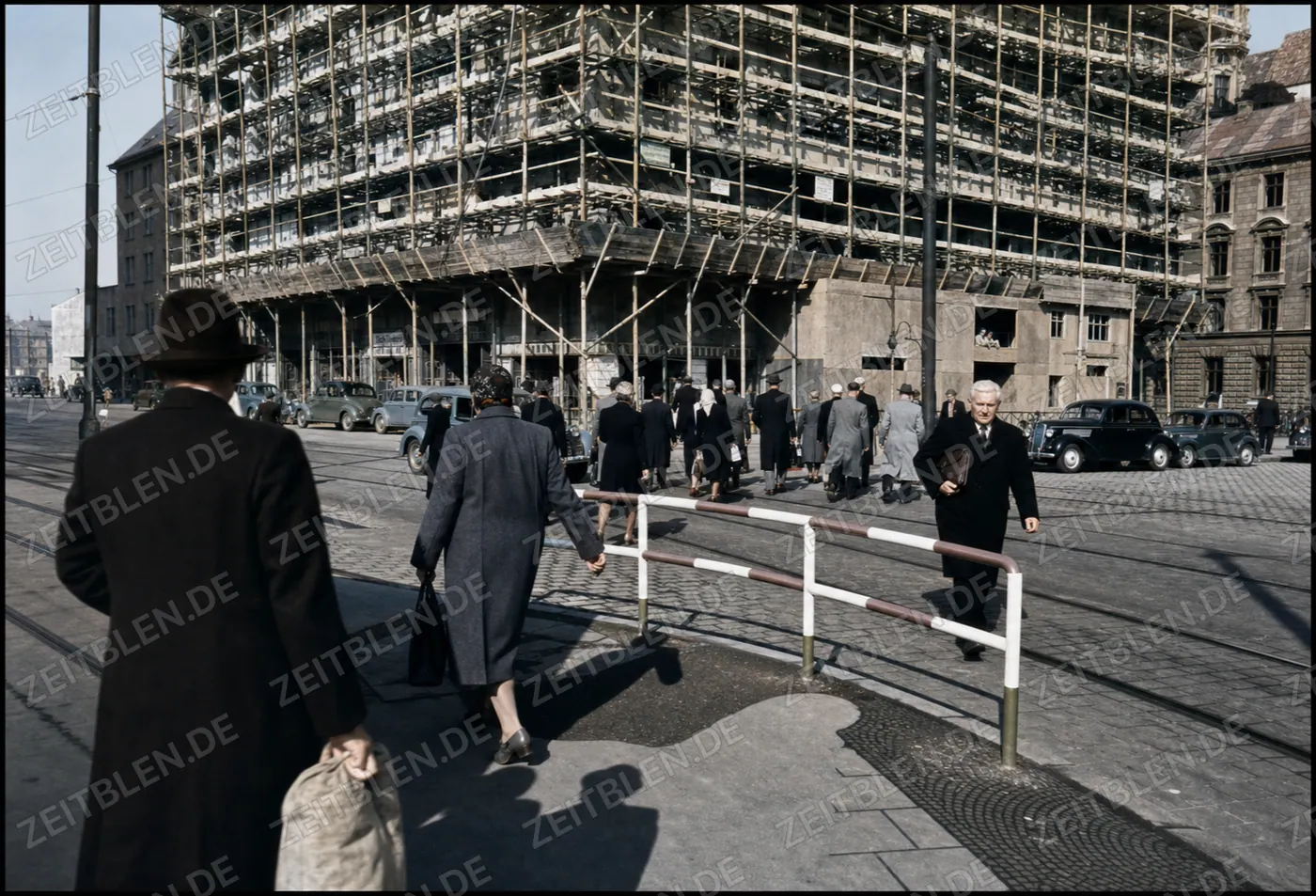Fußgänger an Münchner Straßenbahngleisen vor Gerüstbau