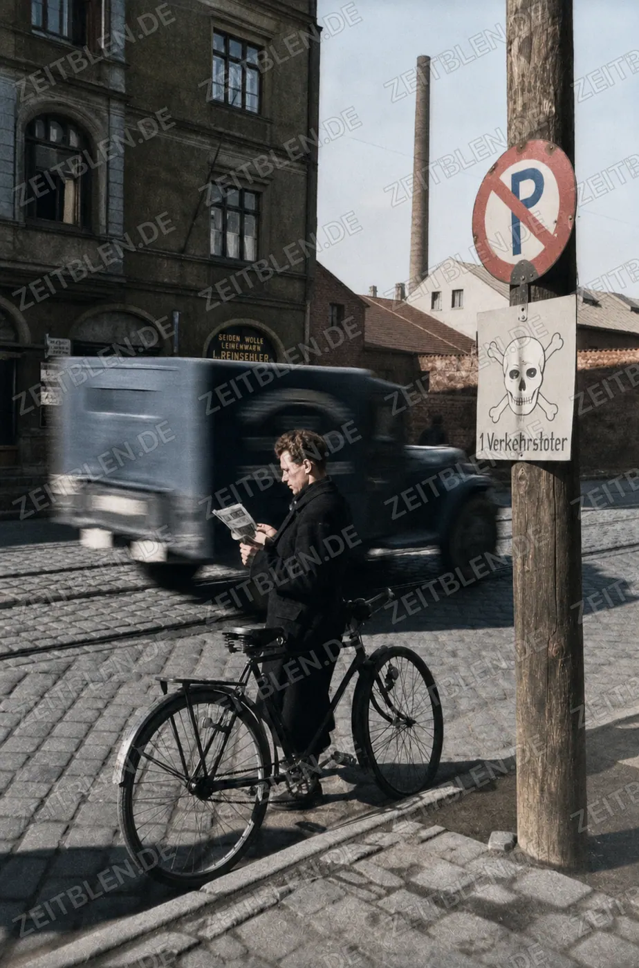 Mann mit Fahrrad unter Verkehrstoten-Warnschild