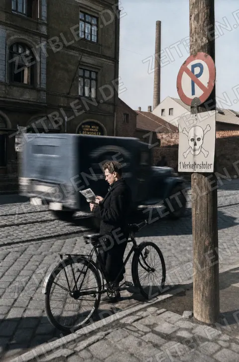 Mann mit Fahrrad unter Verkehrstoten-Warnschild