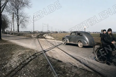 Auto und Radfahrer an unbeschranktem Bahnübergang