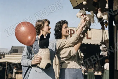 Besucherinnen mit Plüschtieren und Ballon auf dem Oktoberfest