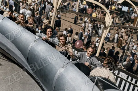 Wiesn-Besucherinnen in einem schienengeführten Fahrgeschäft