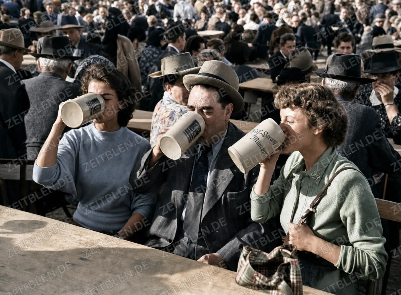 Drei Oktoberfestbesucher trinken aus Bierkrügen