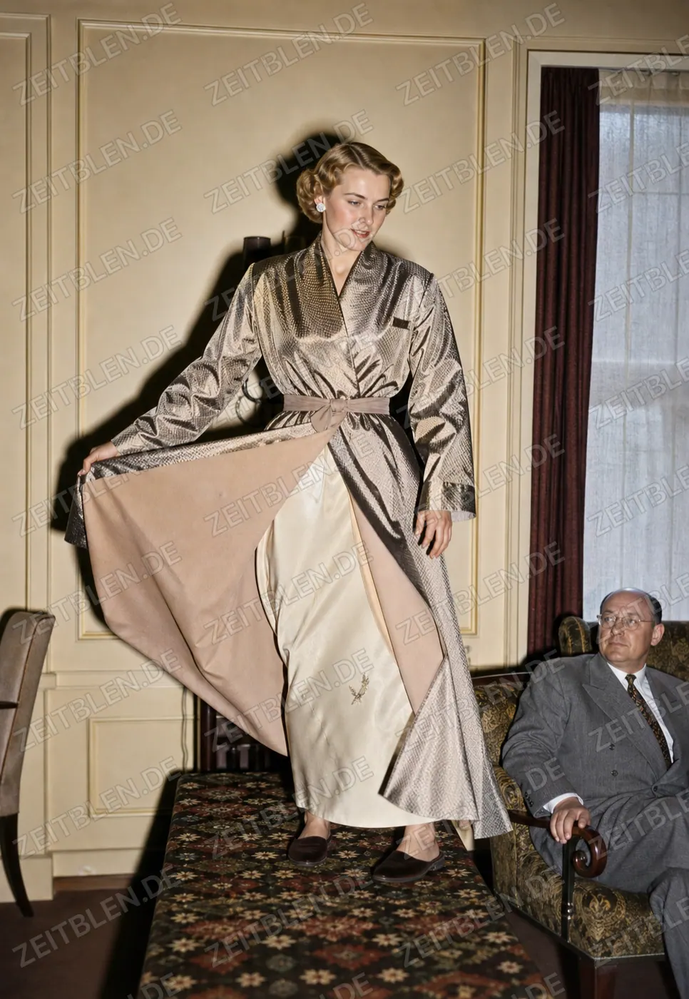 Hettlage-Mannequin mit weitem Abendkleid und glänzendem Überwurf