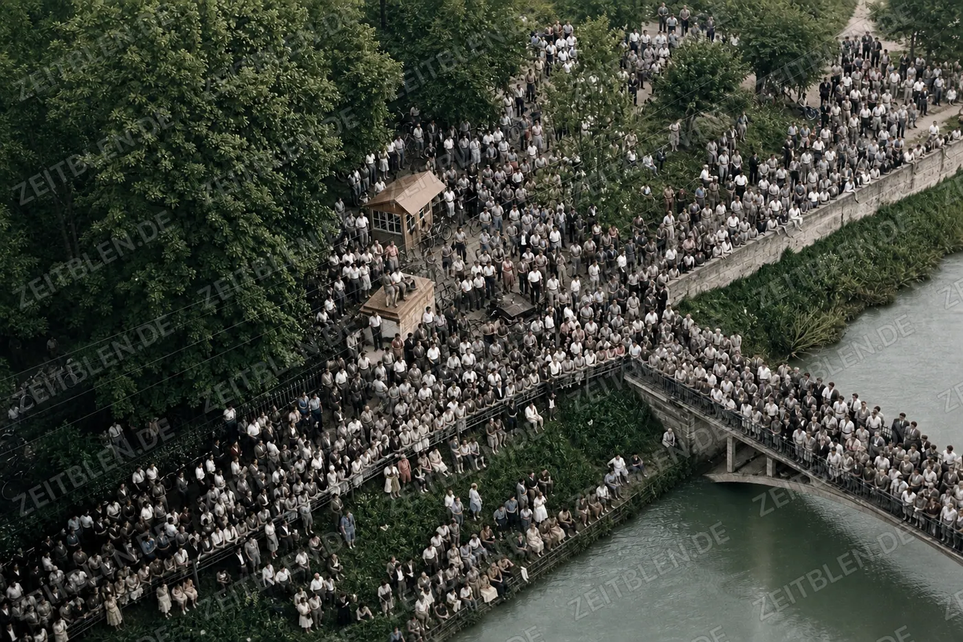 Große Menschenmenge an der Isar mit Fußbrücke