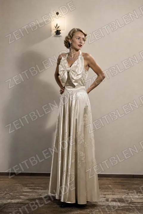 Modell in besticktem Ensemble bei einer Modeschau in Hellabrunn