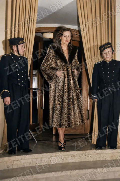 Model im Leopardenmantel mit Hotelpagen im Hotel Drei Mohren