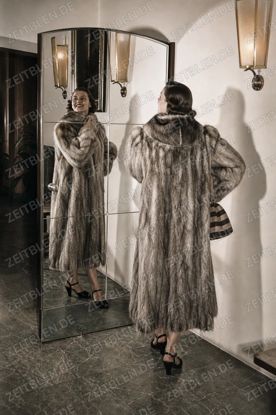 Model im hellen Pelzmantel vor dem Spiegel im Hotel Drei Mohren
