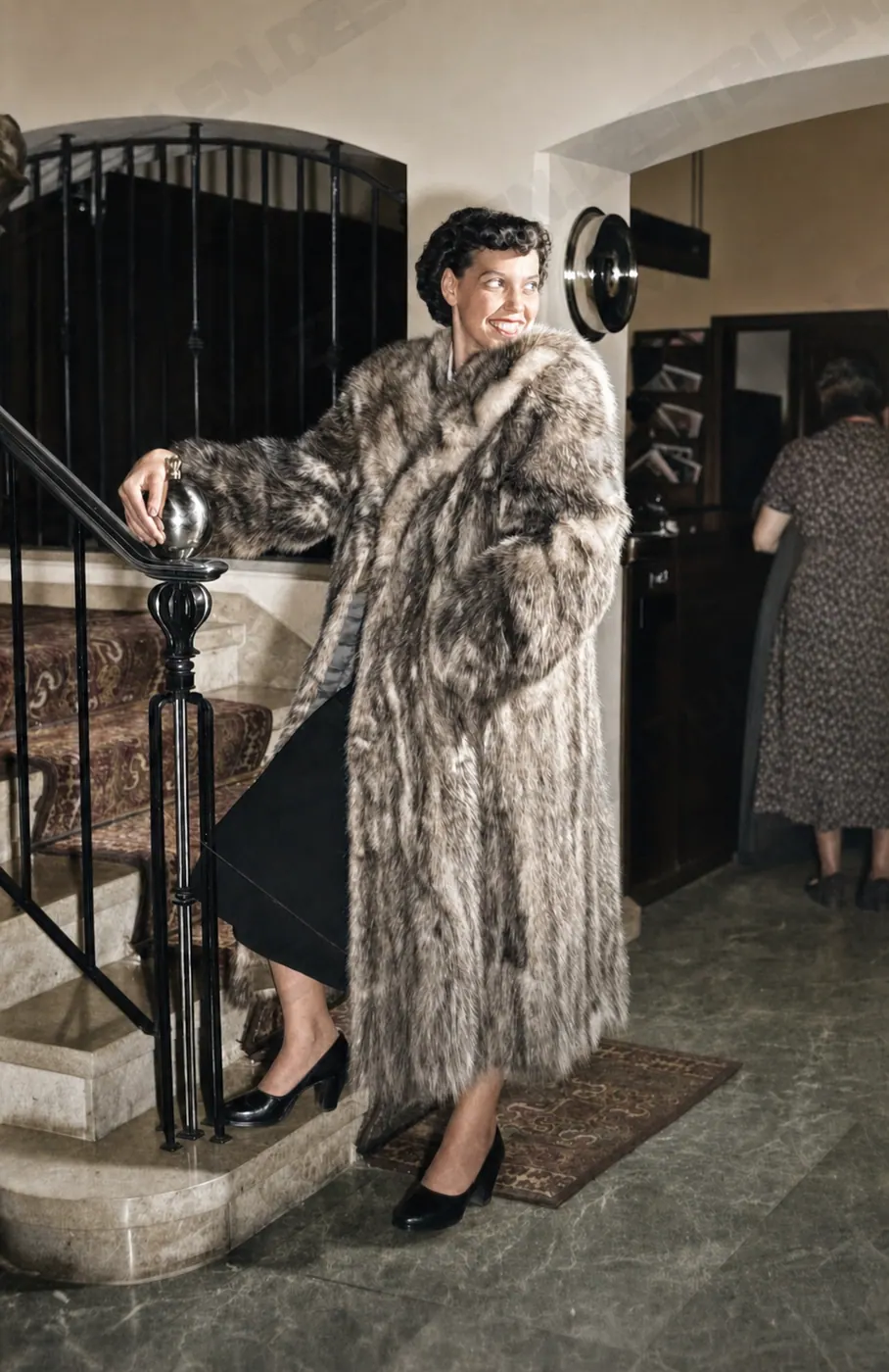Model im hellen Pelzmantel auf der Treppe des Hotel Drei Mohren