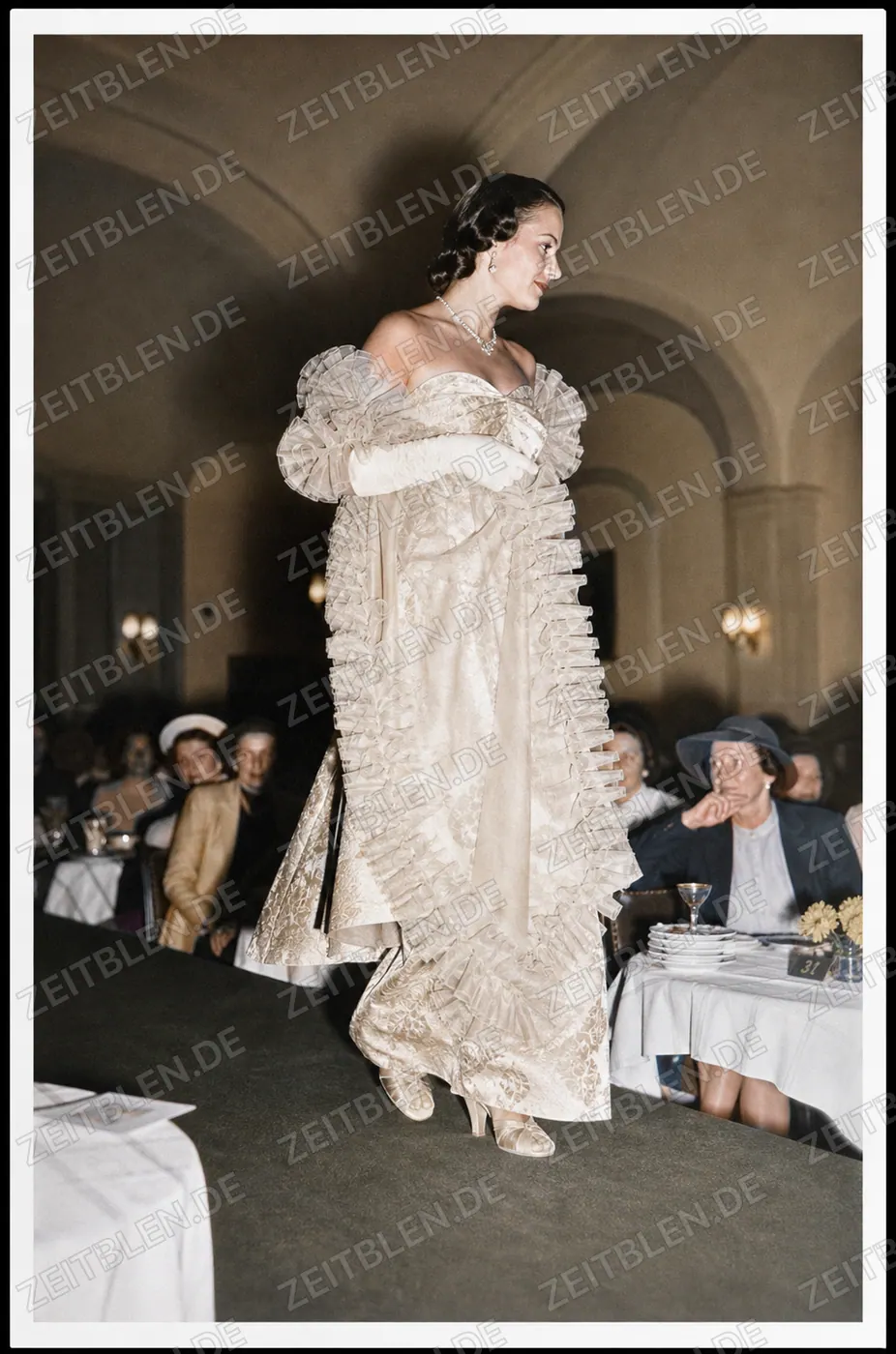 Modell im gerüschten Kleid bei einer Modeschau im Bayerischen Hof
