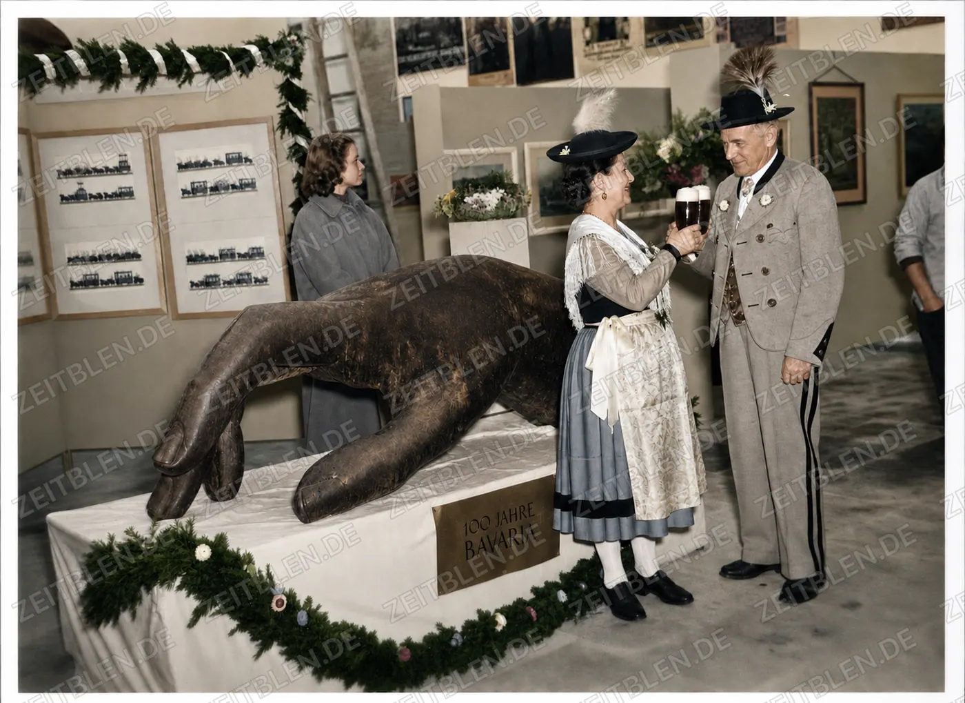 Trachtenpaar am Löwenexponat der Bavaria-Ausstellung