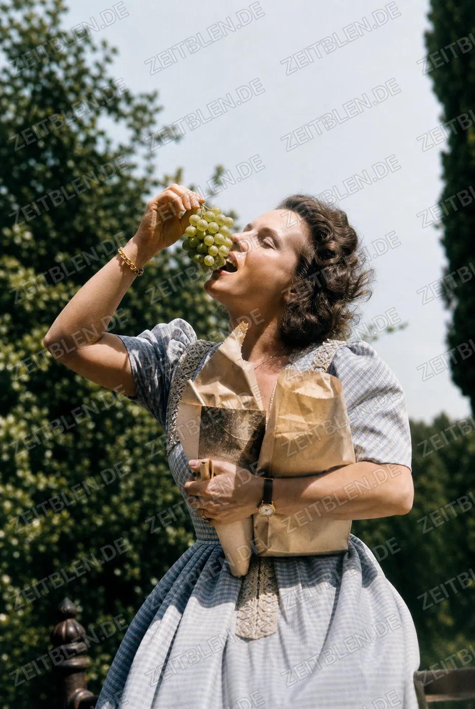 Magda Schneider mit Weintrauben im Freien